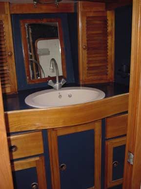 Vista parcial del baño de proa, acabado en madera maciza de cerezo.